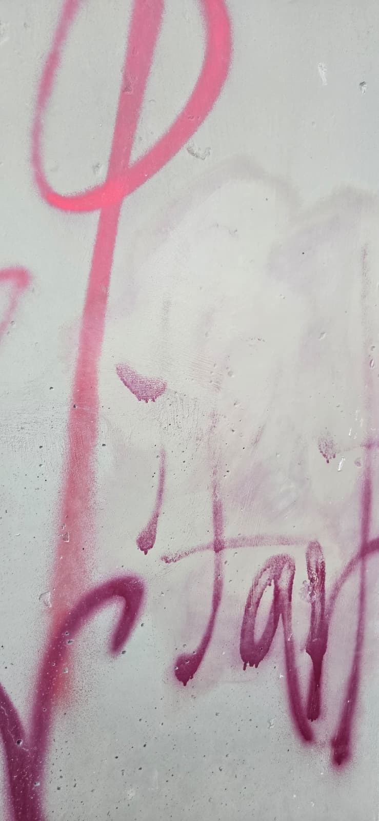 Graffiti fading on concrete wall during removal with GraffitiWipe